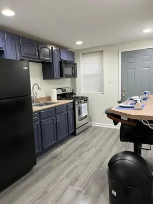 a kitchen with blue cabinets and a wooden table at Cozy Home located in a prime area. in Philadelphia