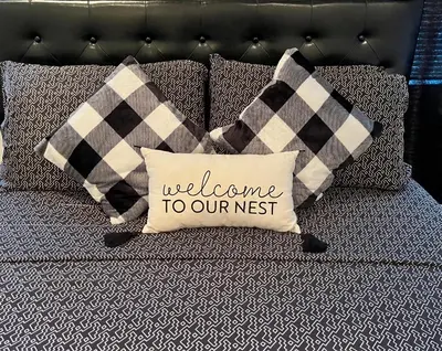 a pillow that says welcome to our nest on a couch at Cozy Home located in a prime area. in Philadelphia