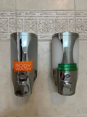 two trash cans on the wall of a bathroom at Cozy Home located in a prime area. in Philadelphia