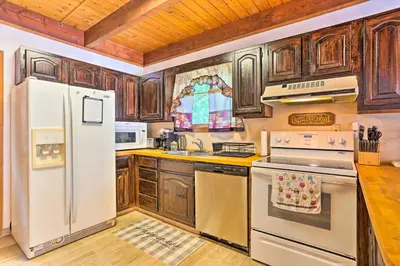 a kitchen with wooden cabinets and a white refrigerator at Bushkill House with Deck and Community Amenities! in Bushkill