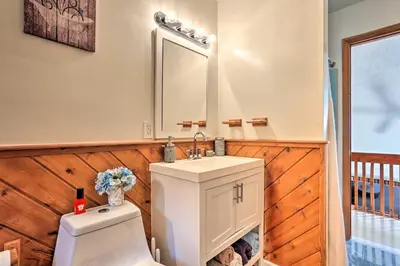 a bathroom with a toilet and a sink and a mirror at Bushkill House with Deck and Community Amenities! in Bushkill