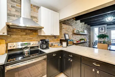 a kitchen with white cabinets and a stove top oven at Mtn-View Gem with Deck and Hot Tub in Tannersville in Tannersville