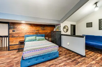 a bedroom with a blue bed and a wooden wall at Mtn-View Gem with Deck and Hot Tub in Tannersville in Tannersville