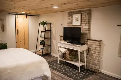 a bedroom with a bed and a flat screen tv at The Carriage House at Strasburg in Strasburg