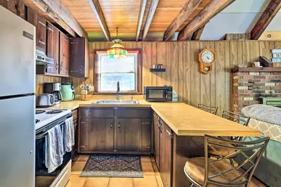a kitchen with wooden cabinets and a counter top at Game Room and Fire Pit Tree-Lined Pocono Lake Cabin in Pocono Lake