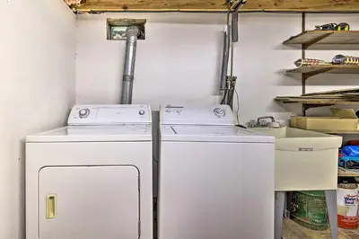 two washing machines in a room with shelves at Game Room and Fire Pit Tree-Lined Pocono Lake Cabin in Pocono Lake