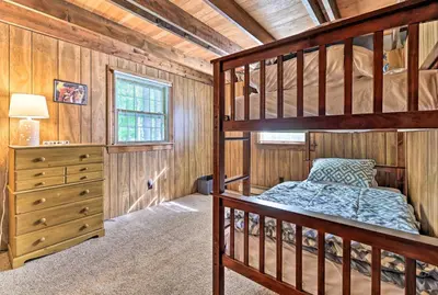 a bedroom with two bunk beds and a dresser at Game Room and Fire Pit Tree-Lined Pocono Lake Cabin in Pocono Lake