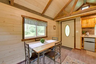 a dining room with a table and chairs and a window at Tranquil Creekside Cabin in Dutch Country! in Narvon