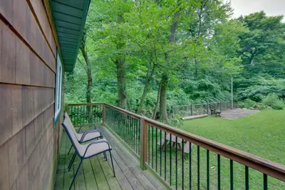 two chairs sitting on a deck with a yard at Tranquil Creekside Cabin in Dutch Country! in Narvon
