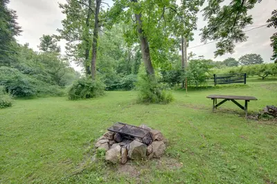 a tree stump in a field with a picnic table at Tranquil Creekside Cabin in Dutch Country! in Narvon