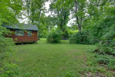 a small house in the middle of a yard at Tranquil Creekside Cabin in Dutch Country! in Narvon