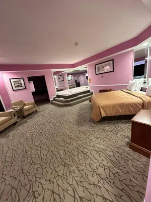a hotel room with two beds and purple walls at Inn of the Dove Harrisburg-Hershey Romantic Suites in Harrisburg