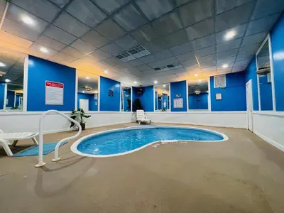 a large swimming pool in a room with blue walls at Inn of the Dove Harrisburg-Hershey Romantic Suites in Harrisburg