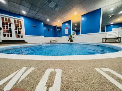 a large swimming pool in a room with blue walls at Inn of the Dove Harrisburg-Hershey Romantic Suites in Harrisburg
