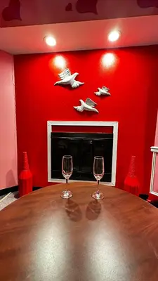 two wine glasses on a table in a room with a fireplace at Inn of the Dove Harrisburg-Hershey Romantic Suites in Harrisburg