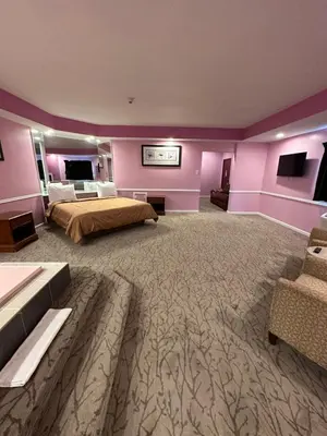 a large bedroom with a large bed and purple walls at Inn of the Dove Harrisburg-Hershey Romantic Suites in Harrisburg