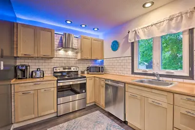 a kitchen with wooden cabinets and stainless steel appliances at 7 Mi to Tobyhanna State Park Quiet Retreat! in Tobyhanna