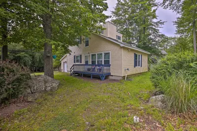 a yellow house with a blue bench in the yard at 7 Mi to Tobyhanna State Park Quiet Retreat! in Tobyhanna