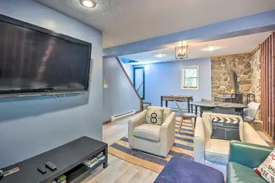 a living room with a large flat screen tv at Wraparound Deck Big Bass Lake Home in Gouldsboro in Gouldsboro