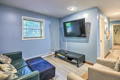 a living room with a couch and a flat screen tv at Wraparound Deck Big Bass Lake Home in Gouldsboro in Gouldsboro