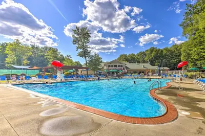 a large swimming pool at a resort with people in it at Wraparound Deck Big Bass Lake Home in Gouldsboro in Gouldsboro