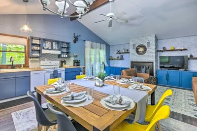 a kitchen and dining room with a wooden table and yellow chairs at Wraparound Deck Big Bass Lake Home in Gouldsboro in Gouldsboro