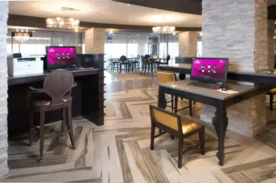 a restaurant with two computers on a table with chairs at Crowne Plaza Saddle Brook by IHG in Saddle Brook