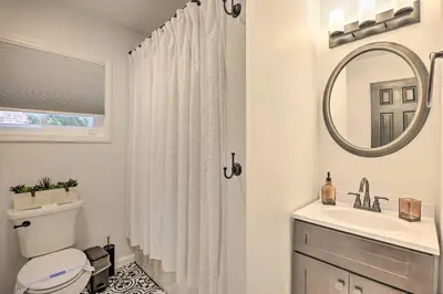 a bathroom with a toilet and a sink and a mirror at Fire Pit and Furnished Deck Serene Tobyhanna Escape in Tobyhanna