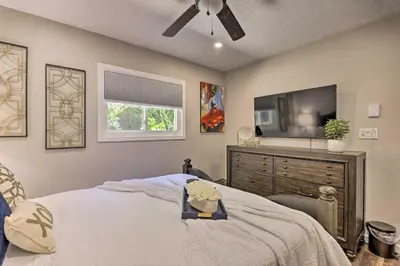 a bedroom with a bed with a dresser and a window at Fire Pit and Furnished Deck Serene Tobyhanna Escape in Tobyhanna
