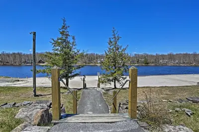 a gate with trees in a park next to a lake at Fire Pit and Furnished Deck Serene Tobyhanna Escape in Tobyhanna