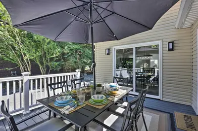 a table with an umbrella on a porch at Fire Pit and Furnished Deck Serene Tobyhanna Escape in Tobyhanna