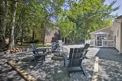 a backyard with chairs and a fire pit and trees at Fire Pit and Furnished Deck Serene Tobyhanna Escape in Tobyhanna
