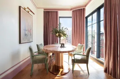 a dining room with a table and chairs and a window at Fouquet's New York in New York