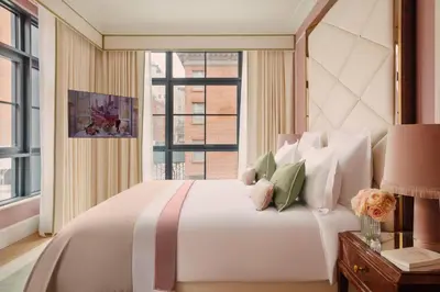 a bedroom with a large white bed with a window at Fouquet's New York in New York