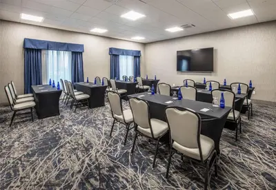 a conference room with tables and chairs and a flat screen tv at DoubleTree by Hilton Monroe Township Cranbury in Monroe Township