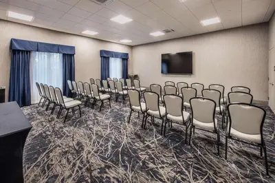 a conference room with chairs and a flat screen tv at DoubleTree by Hilton Monroe Township Cranbury in Monroe Township