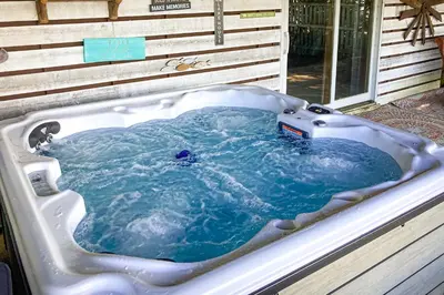 a bath tub filled with blue water in front of a house at Harmony Haven in Lake Harmony