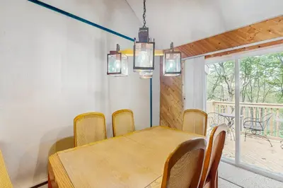 a dining room with a wooden table and chairs at Jumpin' Jack Frost in Lake Harmony