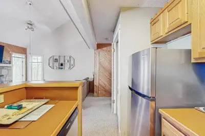 a kitchen with a stainless steel refrigerator and wooden cabinets at Jumpin' Jack Frost in Lake Harmony
