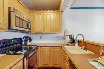 a kitchen with wooden cabinets and a stove and a sink at Jumpin' Jack Frost in Lake Harmony