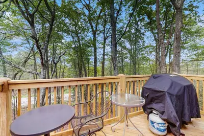 a table and chairs on a deck with an umbrella at Jumpin' Jack Frost in Lake Harmony