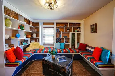 a living room with a long couch with colorful pillows at La Posada in Milford