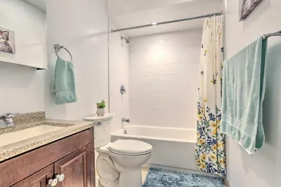 a bathroom with a toilet and a tub and a sink at Sun-Lit Vernon Condo Less Than 2 Mi to Ski Resort! in Vernon Township