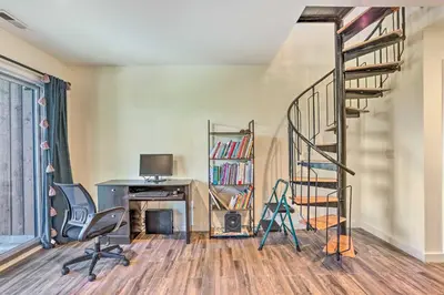 a room with a spiral staircase and a desk at Sun-Lit Vernon Condo Less Than 2 Mi to Ski Resort! in Vernon Township