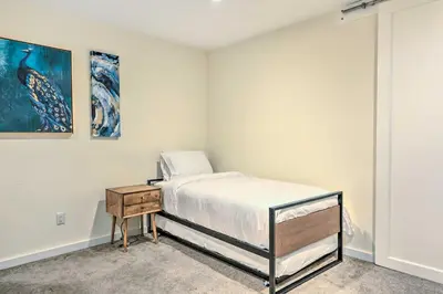 a small bedroom with a bed and a nightstand at Sun-Lit Vernon Condo Less Than 2 Mi to Ski Resort! in Vernon Township