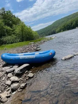 a blue raft sitting on the side of a river at Spacious Catskills Serenity nearby Delaware River Gap w Game Rm Pet Friendly and Fenced Yard in Glen Spey