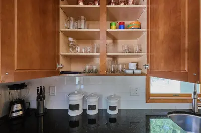 a kitchen with wooden cabinets and a counter top at Spacious Catskills Serenity nearby Delaware River Gap w Game Rm Pet Friendly and Fenced Yard in Glen Spey