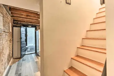 a hallway with stairs and a brick wall at 1850s historic Row House 7min train to NYC with private backyard in Jersey City