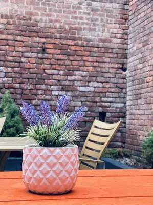 a pink vase with purple flowers sitting on a table at 1850s historic Row House 7min train to NYC with private backyard in Jersey City