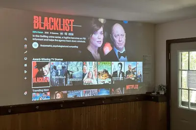 a large screen with a movie on the wall at The Burrow in Jim Thorpe